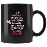 A MOTHER HOLDS HER CHILDRENS HANDS COFFEE MUG
